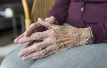 Fokus auf gefalteltete Hände einer alten Dame