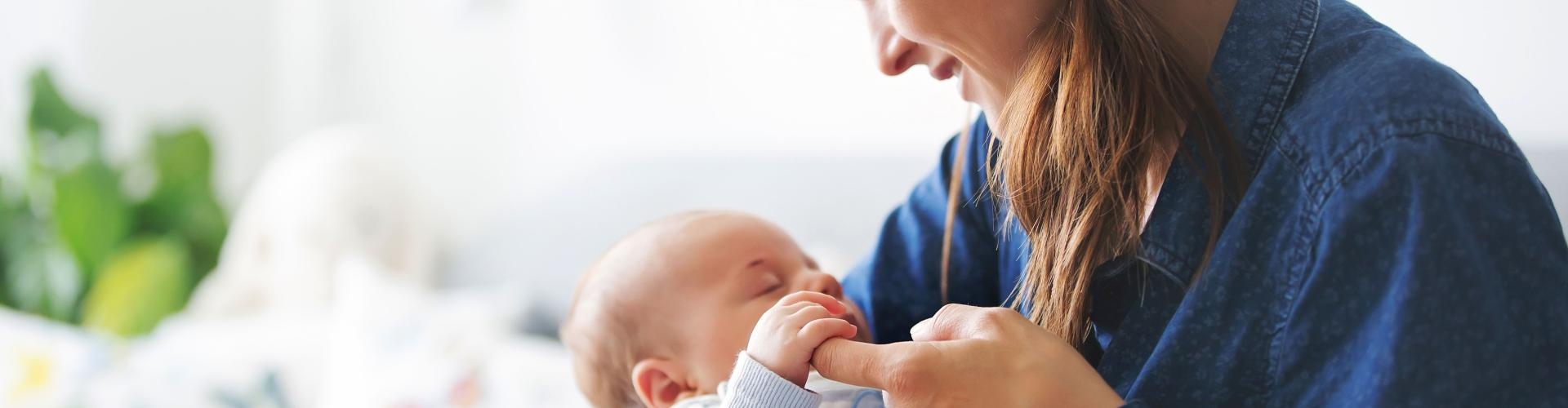 Frau, die einen kleinen Säugling auf dem Arm hält