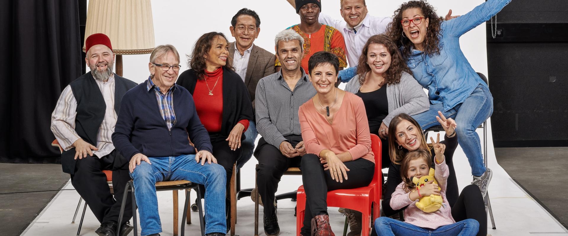 Fröhliche multikulturelle Gruppe posiert in einem Fotostudio vor einer weißen Leinwand