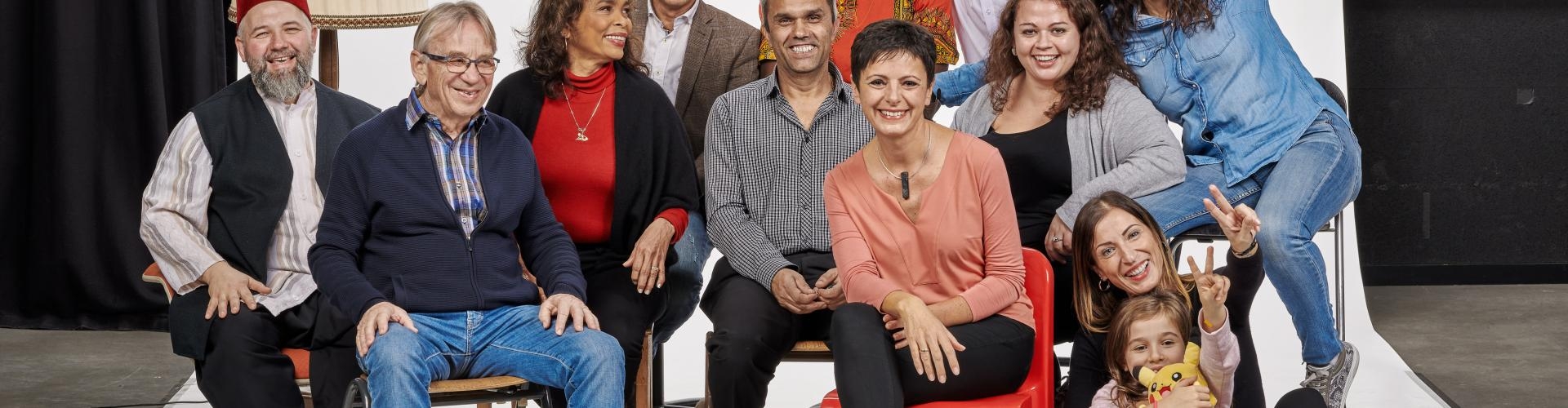 Fröhliche multikulturelle Gruppe posiert in einem Fotostudio vor einer weißen Leinwand
