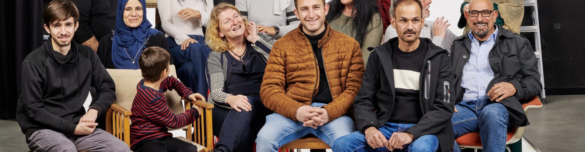 Fröhliche multikulturelle Gruppe posiert in einem Fotostudio vor einer weißen Leinwand