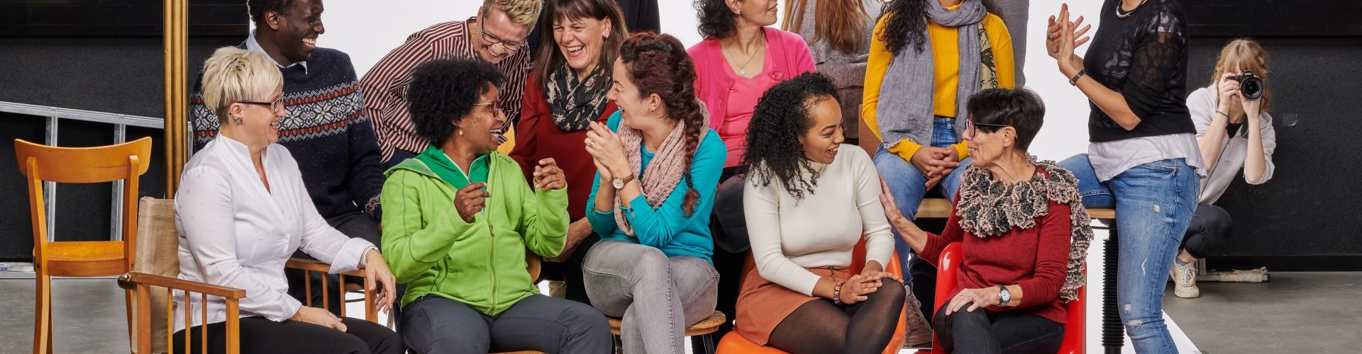 Fröhliche multikulturelle Gruppe posiert in einem Fotostudio vor einer weißen Leinwand