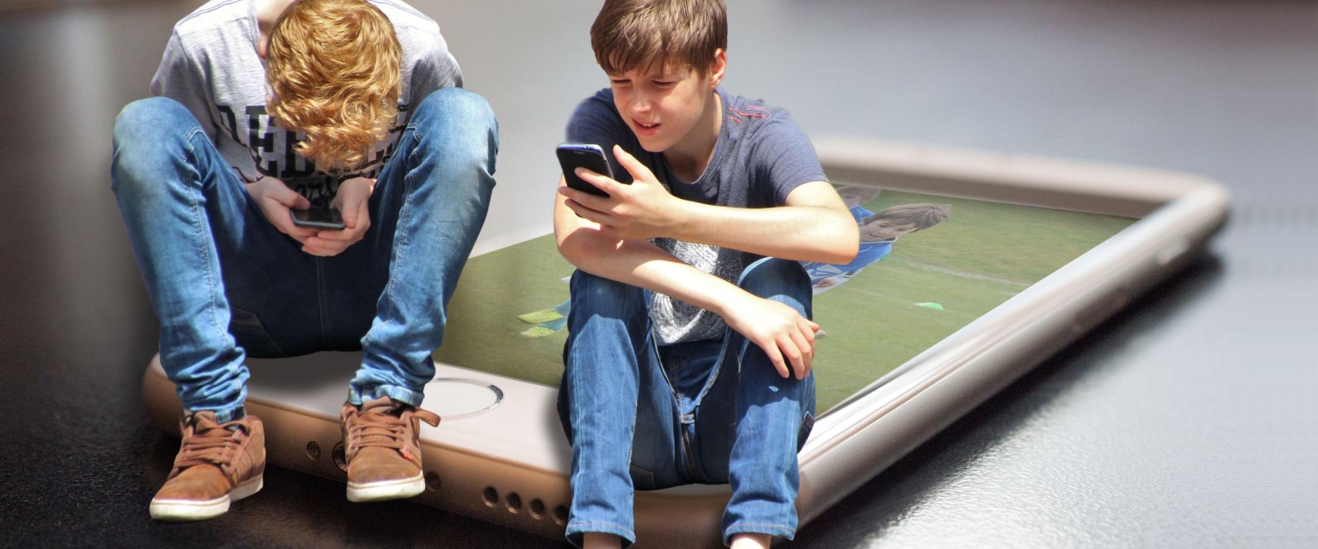 ©Pixabay.Zwei sitzende Teenager mit Smartphones