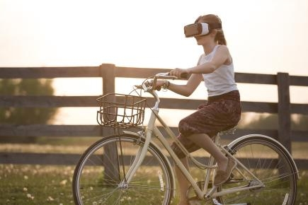 Junges Mädchen auf Fahrrad mit VR Brille Junges Mädchen auf Fahrrad mit VR Brille