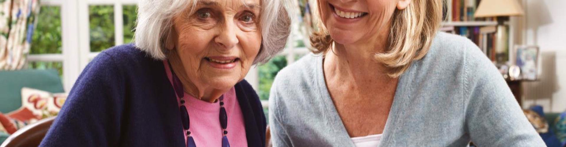 Eine ältere und eine jüngere Dame, die zusammen ein Schreiben betrachten