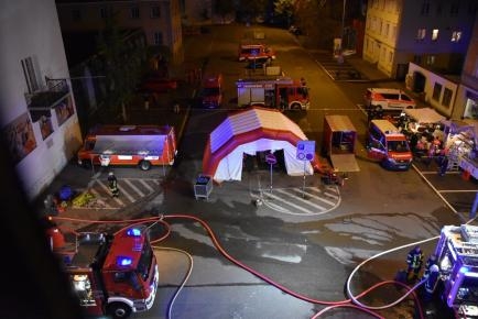 Aufnahme von oben auf eine Straße mit Einsatz von Feuerwehrfahrzeugen und Zelt