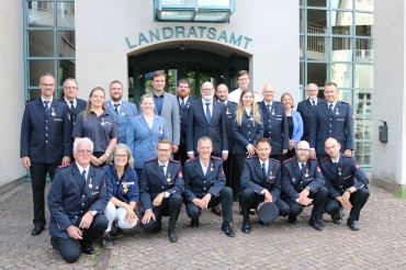 Die Einsatzkräfte in blauen Uniformen in zwei Reihen vor dem Landratsamt mit Landrat Zeno Danner im grauen Anzug und Klemens Ficht im blauen Anzug.