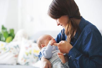 Eine Frau hält einen Säugling auf dem Arm