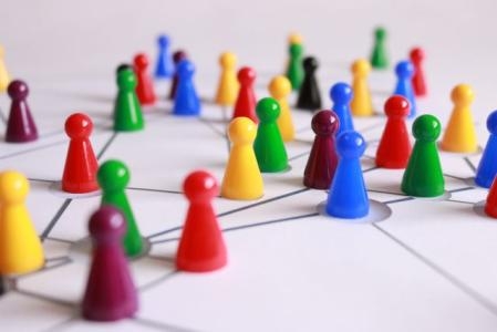 Bunte Spielfiguren auf Untergrund mit auskizzierten Linien